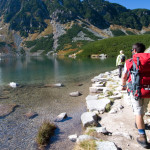 Couple trekking by the side of mountain pond in Tatra Mountains, Poland
